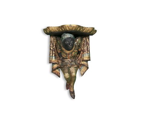 A POLYCHROME CARVED WOOD WALL BRACKET IN THE FORM OF A MALE BLACKAMOOR,supporting a bowfront gilded shelf, 36cm high, 27cm wi