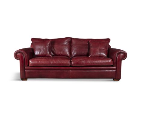 A RED LEATHER THREE-SEATER SOFA BY DURESTA,with opposing out-scrolling arms, fitted with loose seat cushions on block feet; 2