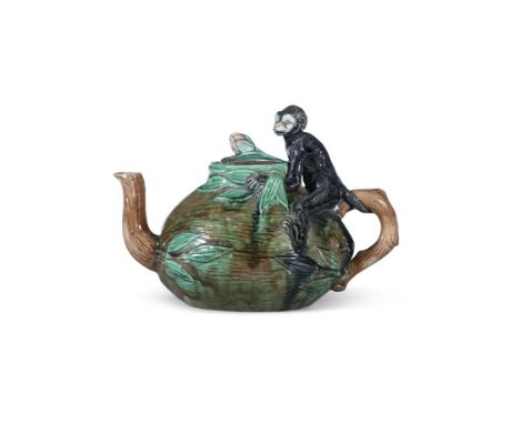 A MAJOLICA GLAZED TEAPOT, C.1820modelled with a monkey, sitting a top a coconut, 19cm high