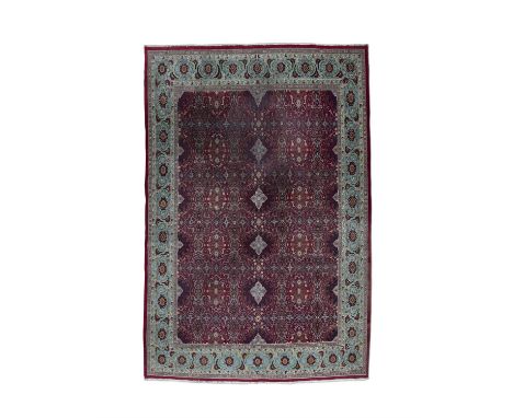 A PERSIAN WOOL CARPET. 340 X 240CMthe red central ground with geometric patterns within a border of foliate scrolls on light 