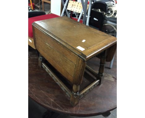 A SMALL OAK DROP LEAF TABLE