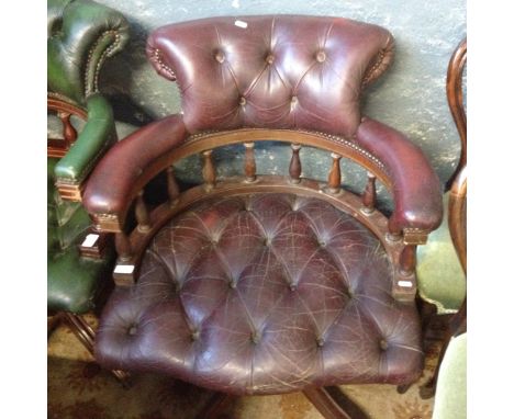 A Chesterfield oxblood button leather swivel chair.