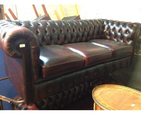 A Chesterfield oxblood button leather three seater settee. L160cm D85cm H75cm.