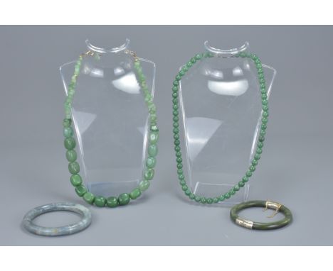 Two jade bead necklaces together with a jade bangle with white metal clasps with one other bangle. (4)