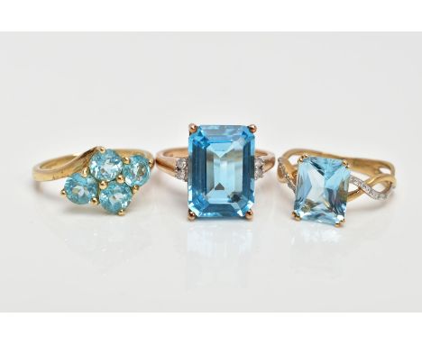 THREE 9CT GOLD TOPAZ DRESS RINGS, the first designed with a rectangular cut blue topaz, flanked with round brilliant cut diam