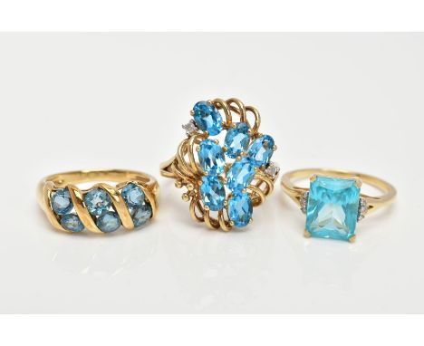 THREE 9CT GOLD TOPAZ DRESS RINGS, the first an openwork cluster set with seven oval cut blue topaz, also set with two single 