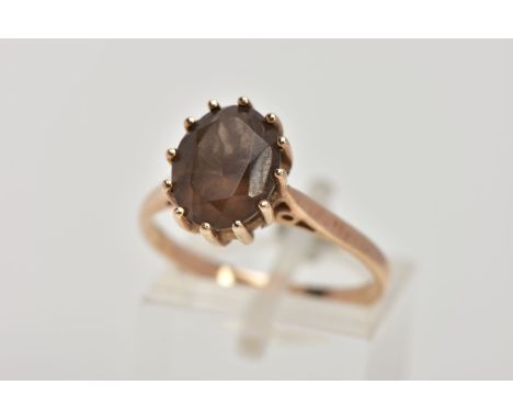 A 9CT GOLD SMOKEY QUARTZ DRESS RING, designed with a twelve claw set, oval cut Smokey quartz, measuring approximately 10.1mm 