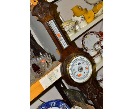 AN EARLY 20TH CENTURY OAK ANEROID BAROMETER, white opaque glass thermometer scale and barometer dial, height 71cm