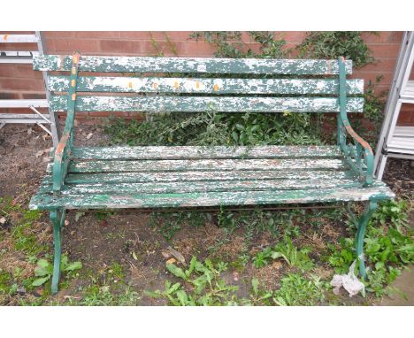 A DISTRESSED GARDEN BENCH 108cm wide with metal scrolled ends and wooden slats
