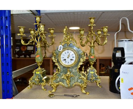 A FRENCH ONYX AND GILT METAL CLOCK GARNITURE, the enamel dial having Roman numeral hours and Arabic minutes, signed Monaco, t