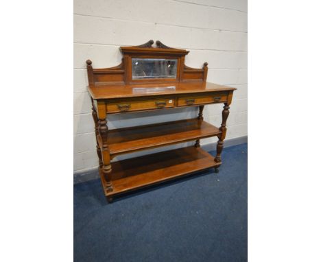 A LATE VICTORIAN OAK THREE TIER BUFFET, having a raised bevelled mirror back, two frieze drawers, turned supports and black c