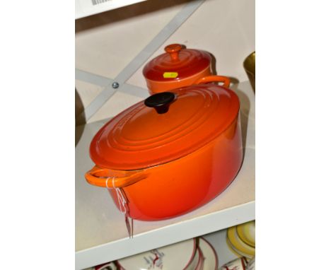 A LE CREUSET ORANGE ENAMELLED OVAL CAST IRON CASSEROLE POT AND COVER, oval 25cm, signs of light use, together with a Le Creus