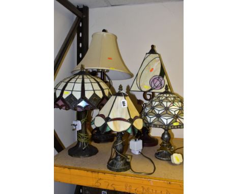 FIVE MODERN METAL BASED TABLE LAMPS, four with leaded and coloured glass shades, and one with a fabric shade, approximate hei