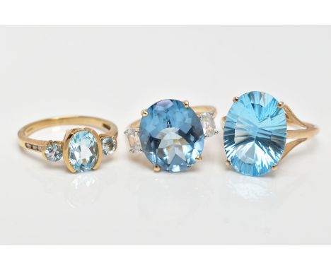 THREE 9CT GOLD DRESS RINGS, the first set with a central oval cut blue topaz, flanked with circular cut aquamarines, and roun