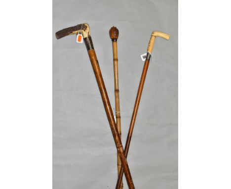 THREE LATE 19TH/EARLY 20TH CENTURY WALKING STICKS, comprising an ivory handled example with carved rope decoration, a Chinese