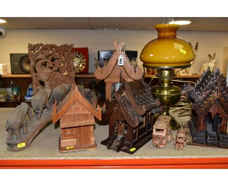 DECORATIVE WOODEN CARVINGS etc, to include Thai Spirit houses, one converted to a lamp, elephants crossing a bridge, carved p