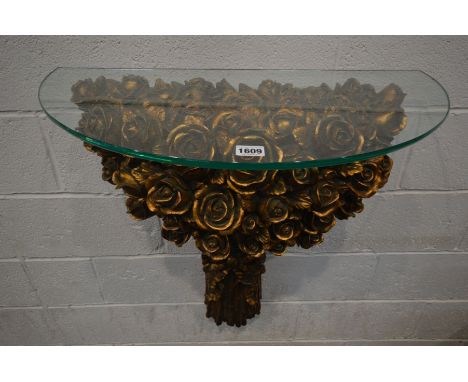 A GILT RESIN ROSE HEAD DECORATED CONSOLE TABLE, with a glass top, width 71cm x height 78cm