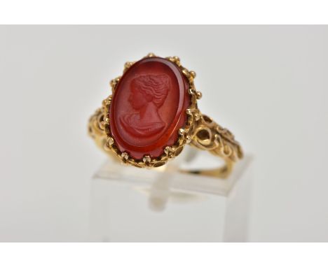 A 9CT GOLD CAMEO RING, oval cameo depicting a lady in profile, carved into possibly carnelian, applied bead work surround, op