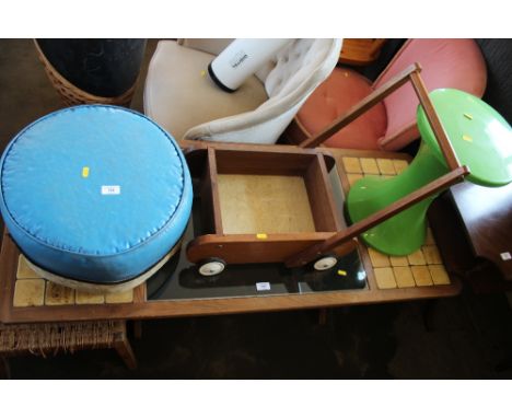 A leather pouffe together with a green plastic stool and child's push trolley
