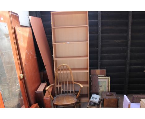 An Ercol style stick back carver chair; a small oak table; and a pine effect open fronted book case