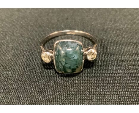 A diamond and moss agate trilogy ring, moss agate cabochon between round brilliant cut diamond shoulders, each approx 0.15ct,