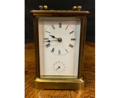 An early 20th century brass carriage clock, Roman numerals, subsidiary seconds dial, bevelled glass, swing handle, 11cm high