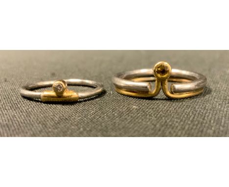 A modern design diamond ring, round brilliant cut diamond side mounted within a yellow gold coloured  T crest, unmarked silve