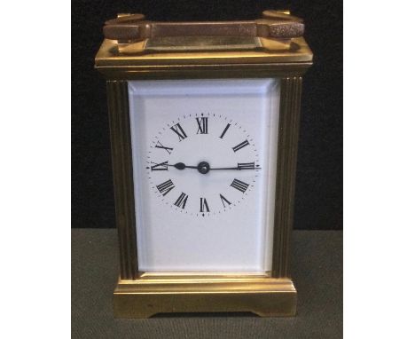 An early 20th century brass carriage clock, white dial, black Roman numerals, bevelled glass panels, 11.5cm high 