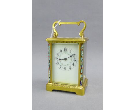 French brass and glass panelled carriage clock, the enamel dial with Arabic numerals flanked by enamelled pilasters, size inc