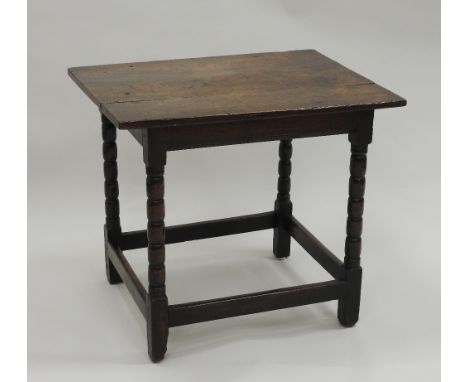 An early 18th century oak tavern table, the rectangular two plank top on four corner bobbin turned supports united by plain s