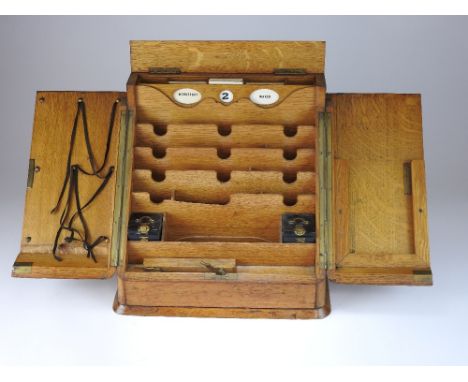 A late Victorian oak stationary box, retailed by Asprey, New Bond Street, the hinged sloping front opening to reveal calendar