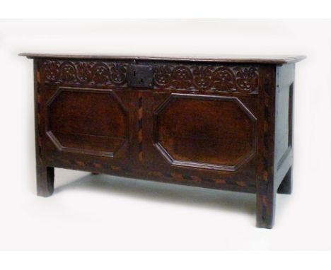 A 17th century north Lancashire oak two panel coffer, the three plank hinged lid over a carved frieze with decoration typical