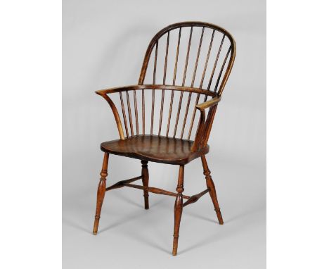 A mid 19th century ash and elm stick back Windsor armchair, with elm saddle seat on slender baluster front legs united by a t