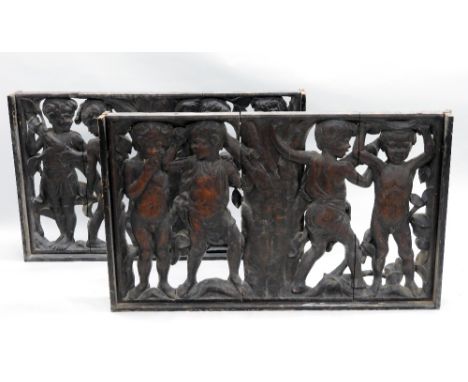 Two late 19th/early 20th century Florentine style carved and pierced dark stained wood panels depicting putti cavorting aroun