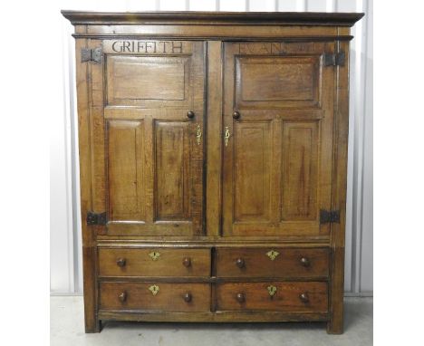 A late 17th century oak livery cupboard, the ogee moulded cornice over two triple fielded panel doors inscribed 'Griffiths Ev