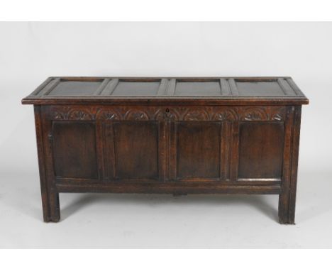 A late 17th / early 18th century joined oak coffer, the four panel hinged lid over a lunette carved frieze and plain four pan