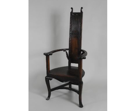 A late 19th century Arts and Crafts style oak open armchair, the narrow two panel back above a boarded seat with wriggle work