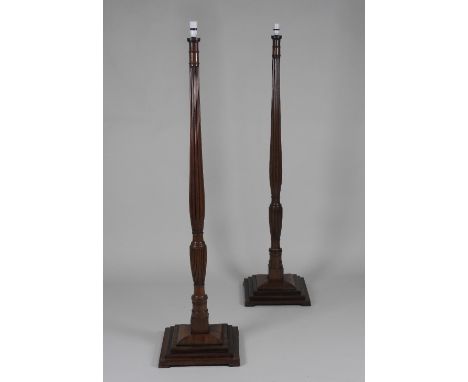 A pair of 19th century and later mahogany lamp standards, each of slender reeded baluster form, on a square stepped base, 179