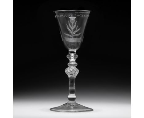 An engraved light-baluster wine glassmid 18th CenturyThe rounded funnel bowl engraved with a thistle and the inscription 'NEM