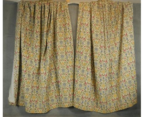 A fair of lined embroidered stylised floral and foliate tapestry design curtains on a cream ground. H.250 W.110 W.310cm 
