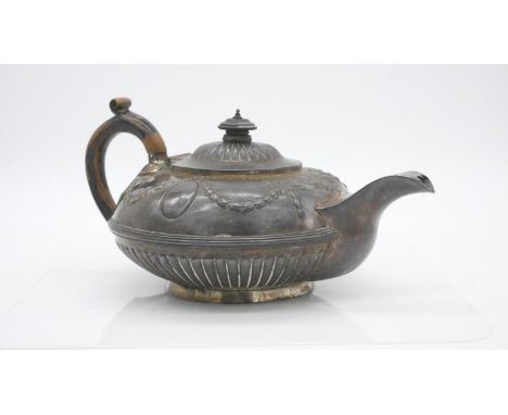 A sterling silver Georgian teapot with dragooned detailing and repousse swag and bow motifs. Hallmarked: IET for I E Terrey &