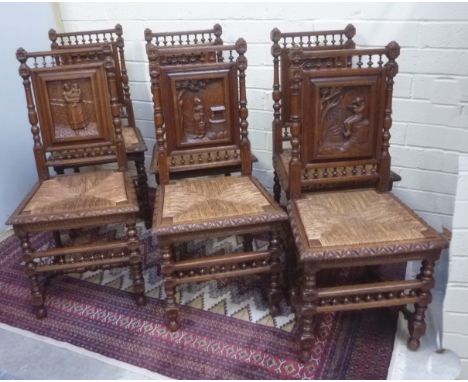 Set of six Flemish style oak chairs with bobbin turned supports, slip in rush seats with carved scenes to back.