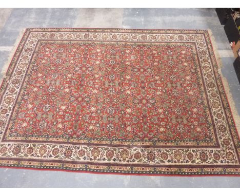 Large modern Pakistan carpet the red ground with floral design and beige border, 256cm x 342cm.