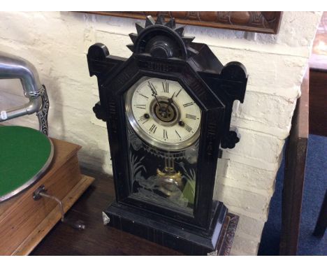A carved stained walnut cased American style eboniesed finish mantle clock.