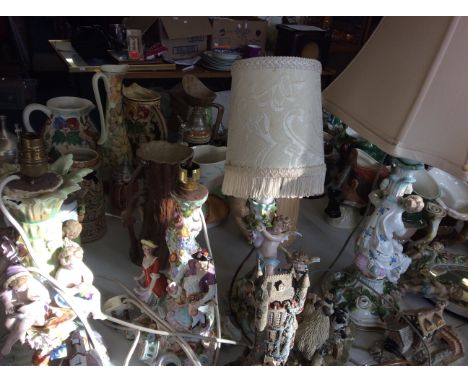 Four ceramic lampshades with intricate floral detail and figurines.