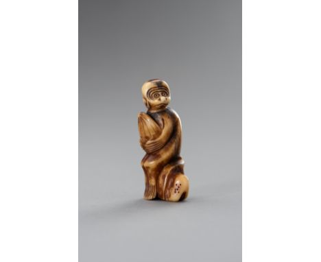 A STAG ANTLER NETSUKE OF A MONKEY HOLDING A PEACHJapan, Meiji period (1868-1912)Depicting a monkey seated on a rocky base, cl