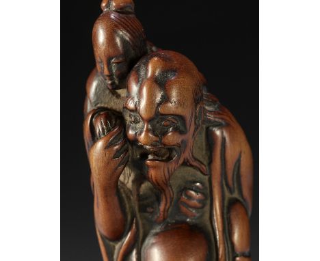 A TALL EARLY EDO SCHOOL WOOD NETSUKE OF IKKAKU SENNIN CARRYING THE LADY OF BENARESUnsignedJapan, Edo (Tokyo), late 18th centu