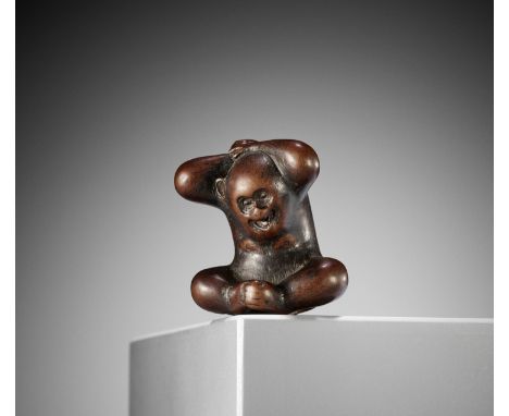 TOMOCHIKA: A RARE WOOD NETSUKE OF A MONKEY WITH PERSIMMONBy Gyokusen Tomochika, signed TomochikaJapan, Kyoto, late 18th to ea