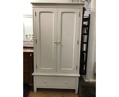 A Victorian style white painted wardrobe, the moulded top with carved frieze above twin panel doors, fitted hanging rail and 