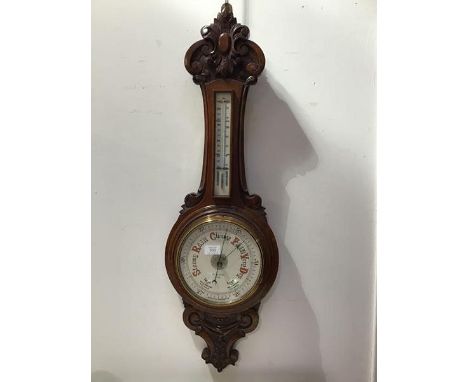 A late 19thc./early 20thc. carved oak banjo barometer, the carved top above a removable cased thermometer, with circular aner